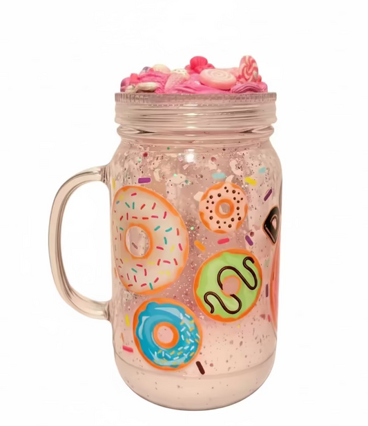 A double wall  mason jar with a handle, filled with pink lava liquid and decorated with colorful donut illustrations. The jar is topped with a clear screw lid and a pink decorative crust made of small pink candies and sprinkles, set against a plain light background.