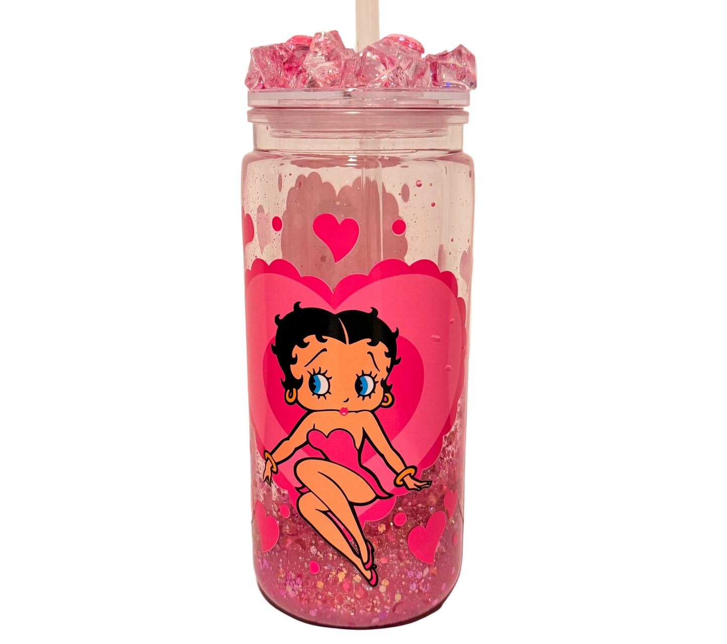 A clear acrylic tumbler with a straw, filled with pink glitter and pink ice, featuring a large pink heart and a cartoon Betty Boop character printed on the front.