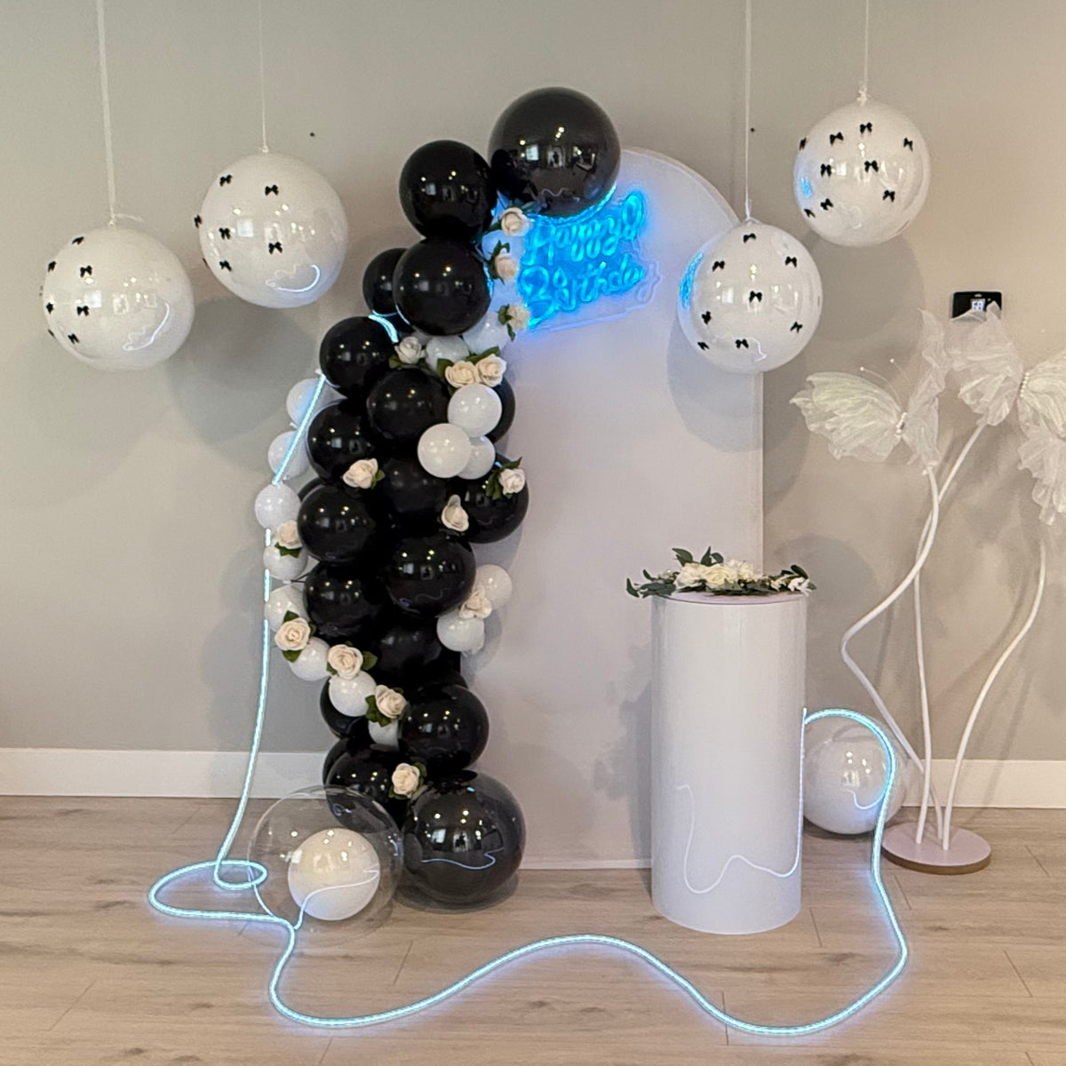 Black and white balloon arch with roses and custom birthday decoration setup